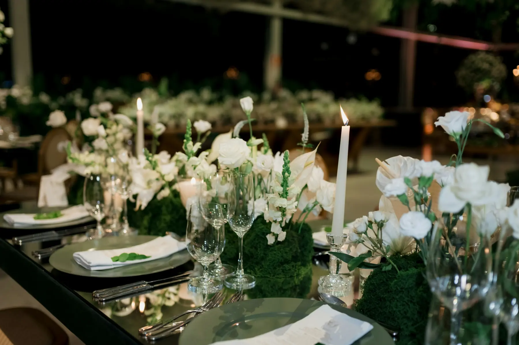 A dinner table set with wine glasses in the evening